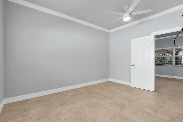 an empty room with fan and windows