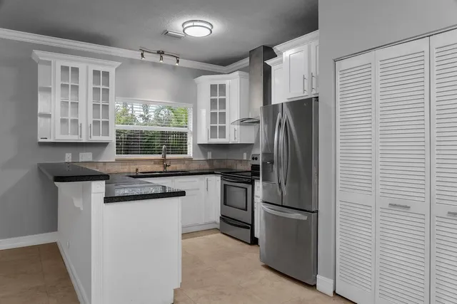 a kitchen with stainless steel appliances granite countertop a refrigerator sink and stove