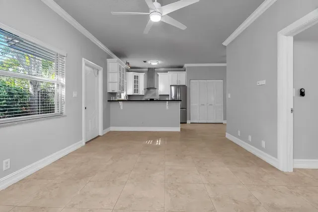 a view of a kitchen with a sink and dishwasher a refrigerator with white cabinets