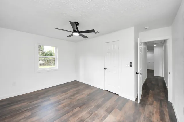 a view of a big room with wooden floor and windows