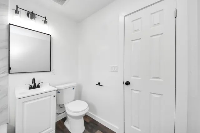 a bathroom with a toilet sink and mirror