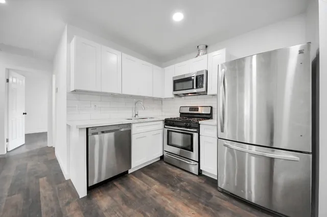 a kitchen with stainless steel appliances a refrigerator sink and microwave