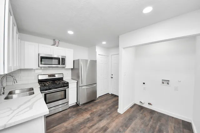 a kitchen with granite countertop a refrigerator and a sink