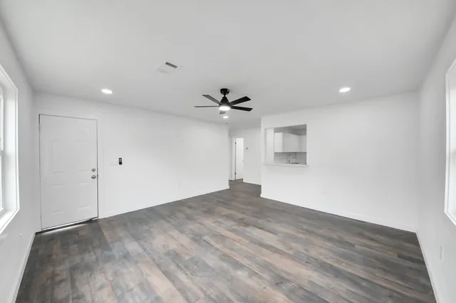 a view of a big room with wooden floor and windows