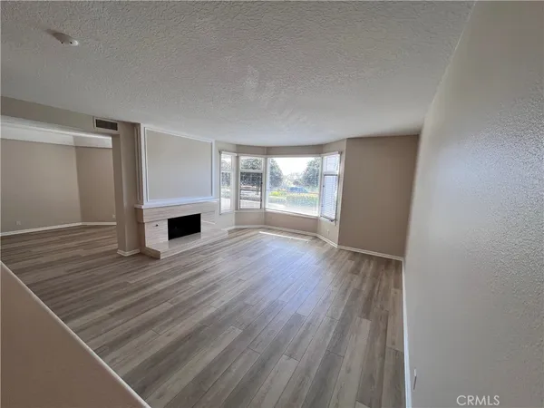 a view of empty room with wooden floor and fireplace