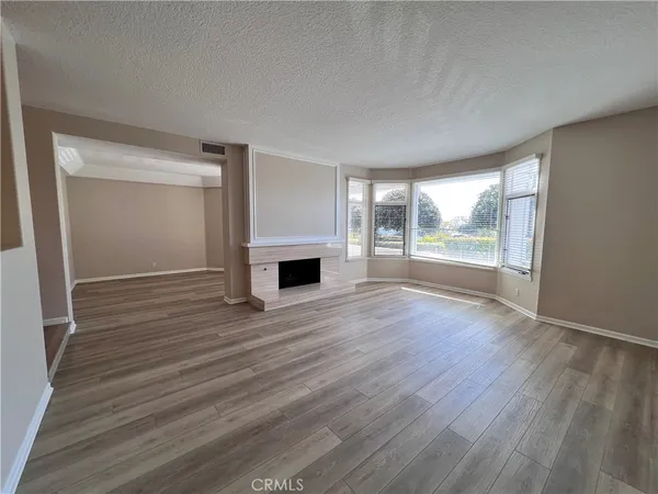 an empty room with wooden floor and fireplace