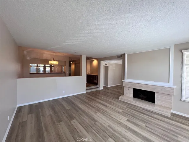 a view of a livingroom with wooden floor and fireplace