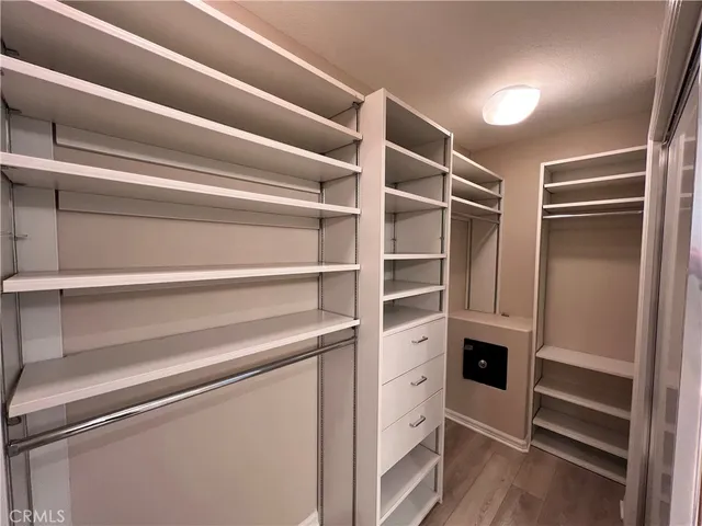 a view of walk in closet with empty racks