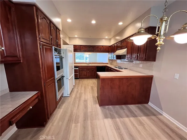 a kitchen with stainless steel appliances granite countertop a refrigerator a sink and a stove