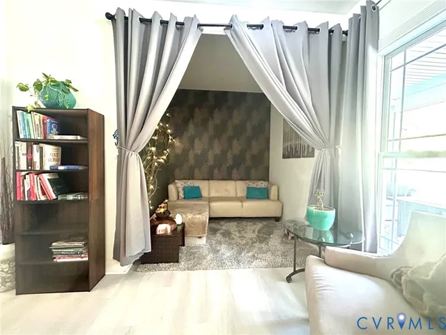 a living room with furniture and a floor to ceiling window