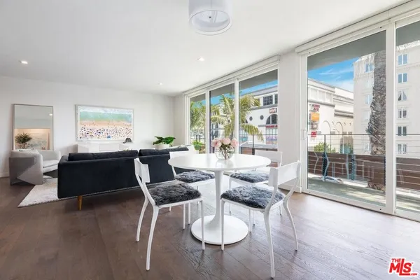 a living room with furniture floor to ceiling window and wooden floor