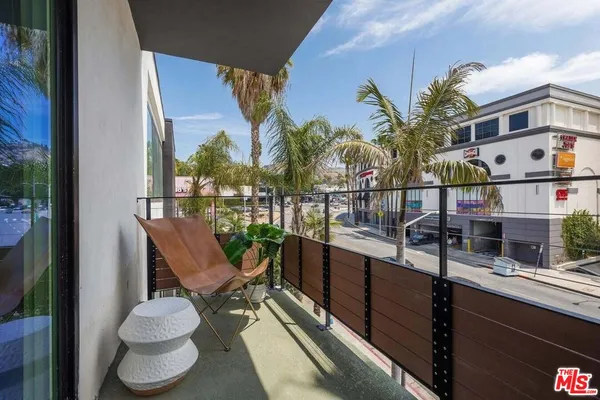 a view of a balcony with chairs and potted plants
