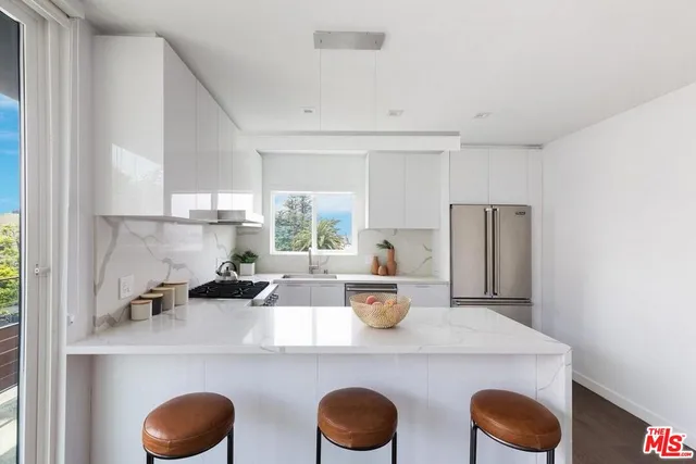 a kitchen with a table chairs a stove a refrigerator and cabinets