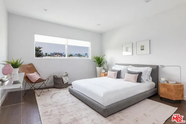 a bedroom with a bed and a potted plant