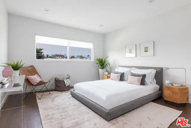 a bedroom with a bed and a potted plant