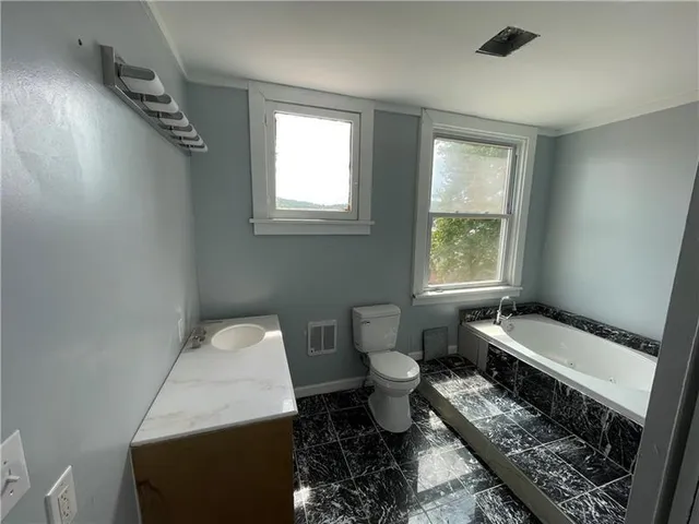 a bathroom with a toilet a sink and a window