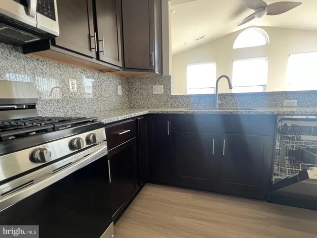 a kitchen with granite countertop a stove and a sink