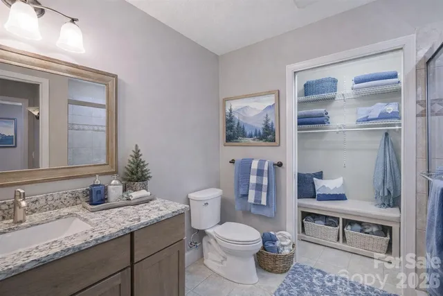 a bathroom with a granite countertop toilet sink and mirror