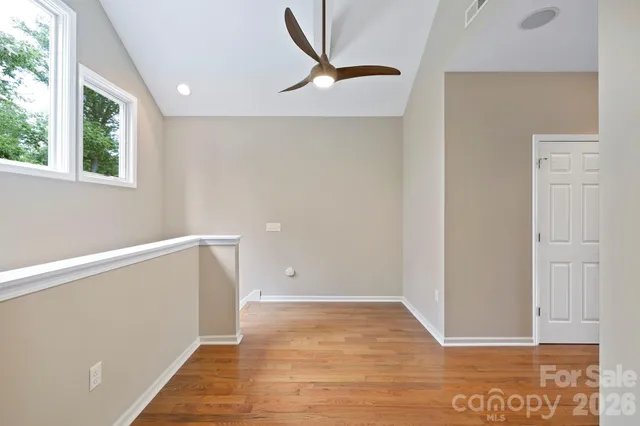 a view of a room with wooden floor and a ceiling fan