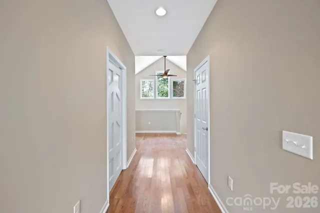 a view of a hallway with wooden floor and a living room