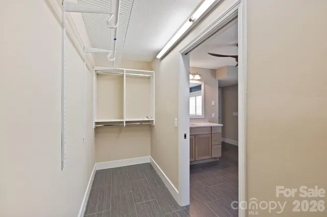 a view of an empty walk in closet with wooden floor