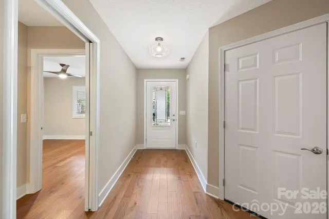 a view of a hallway with wooden floor and closet