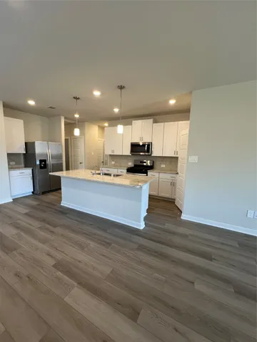 a view of kitchen view wooden floor wooden cabinets and stainless steel appliances