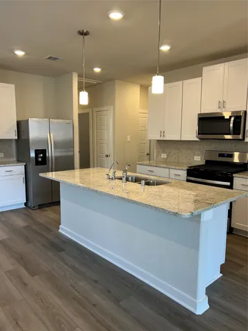 a large kitchen with stainless steel appliances kitchen island granite countertop a large stove a sink a refrigerator and a microwave