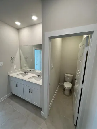 a bathroom with a double vanity sink toilet and shower