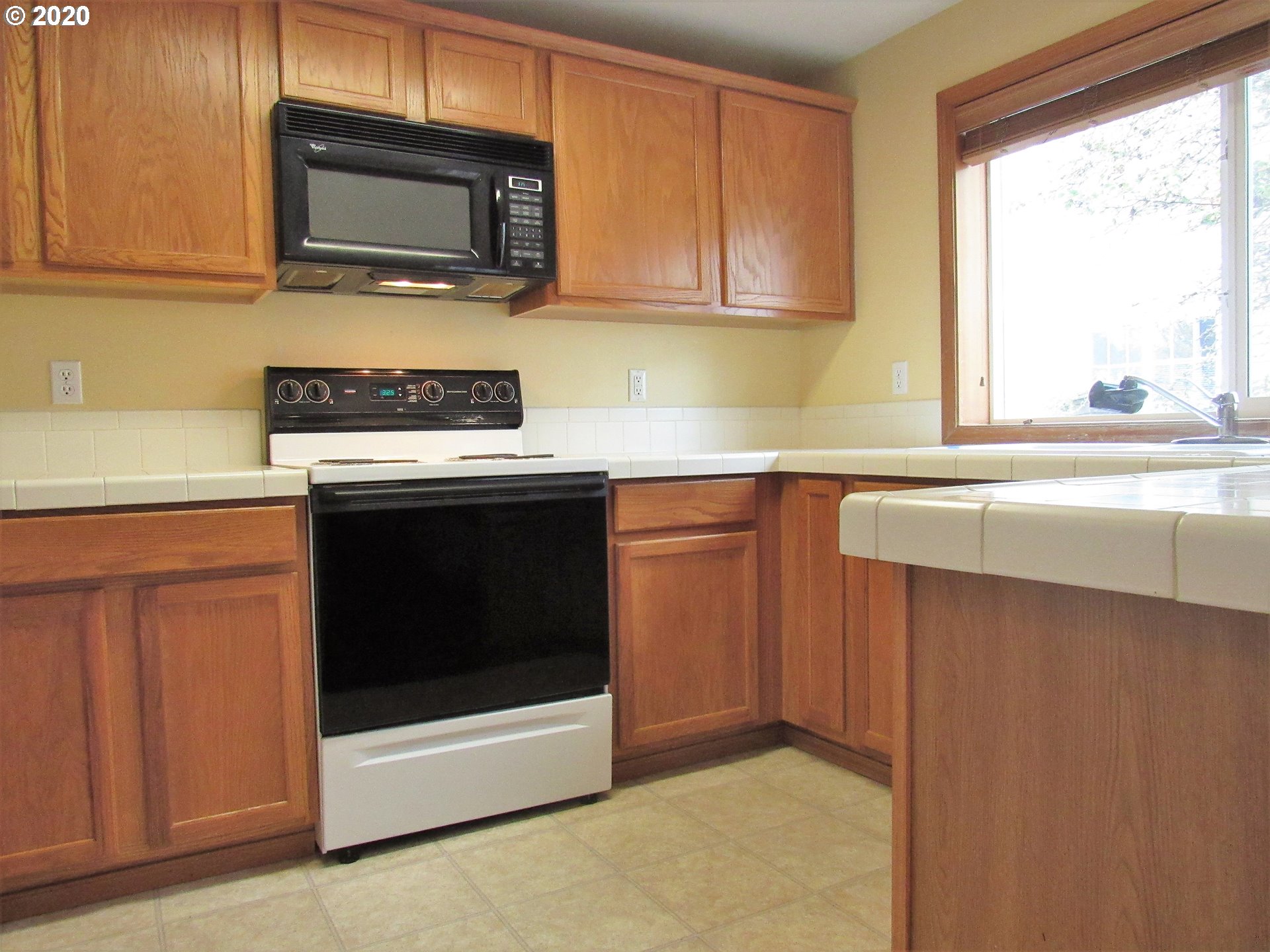 1244 Southwest 160th Avenue, Unit 101 Beaverton, OR 97006 - Photo 2 of 24 a kitchen with a stove microwave and sink
