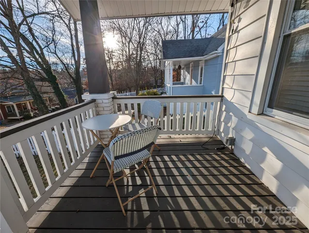 a view of a white house in a big yard with potted plants