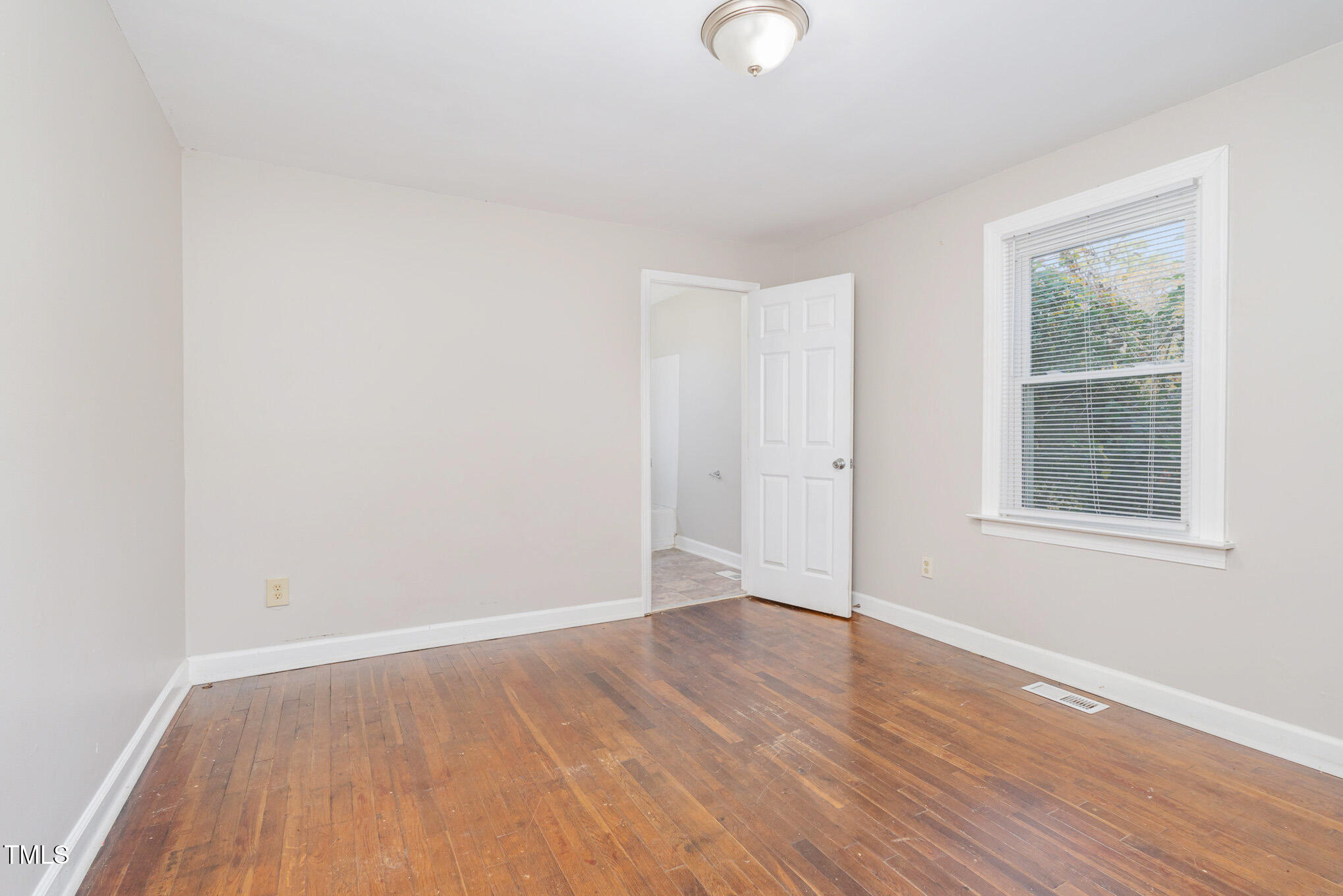 4505 Laymans Chapel Road Durham, NC 27704 - Photo 11 of 20 an empty room with wooden floor and windows