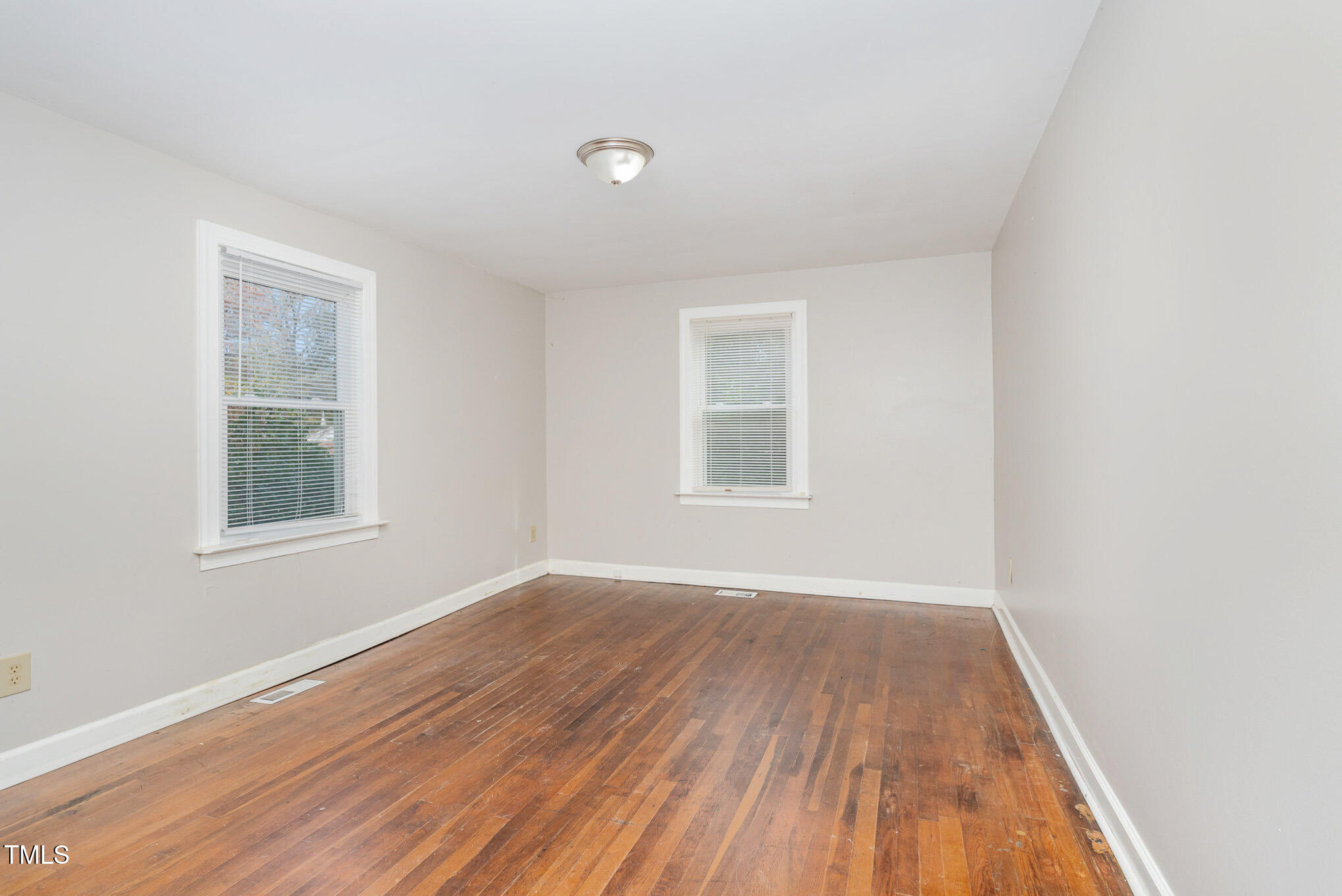 4505 Laymans Chapel Road Durham, NC 27704 - Photo 12 of 20 an empty room with wooden floor and windows