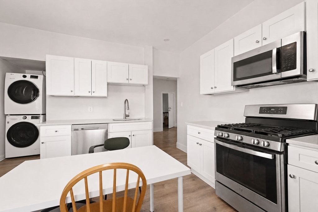 39 Union Street Boston, MA 02135 - Photo 18 of 33 a kitchen with a stove a microwave and cabinets