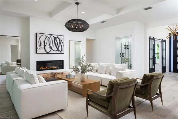 a living room with furniture a fireplace and a chandelier