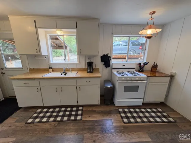 a kitchen with a stove a sink a stove and a window