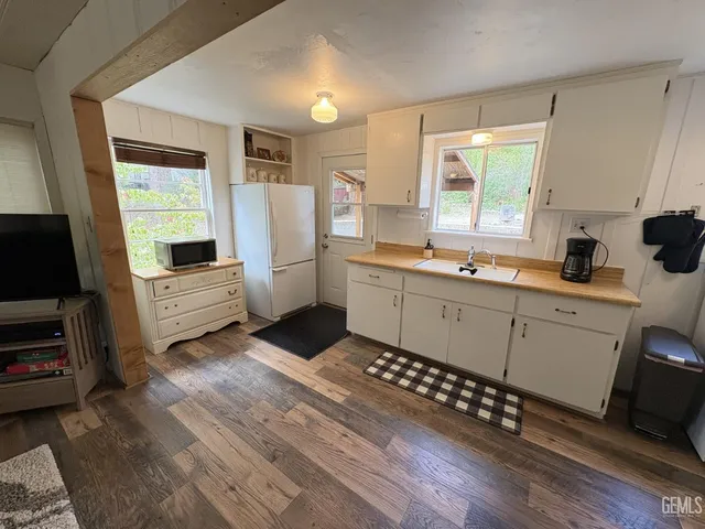 a kitchen with white cabinets and appliances