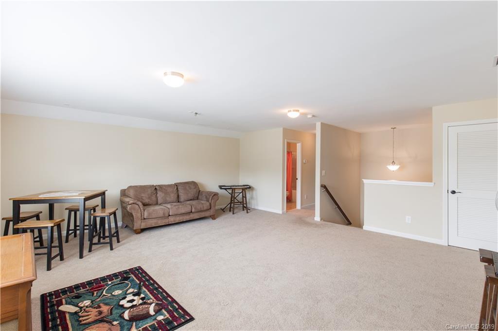 3347 Mandrake Court Tega Cay, SC 29708 - Photo 20 of 27 a living room with furniture a couch and a dining table with wooden floor