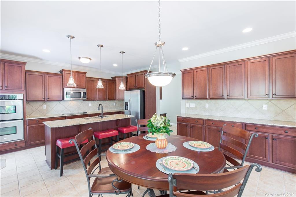 3347 Mandrake Court Tega Cay, SC 29708 - Photo 4 of 27 a kitchen with kitchen island a dining table and chairs