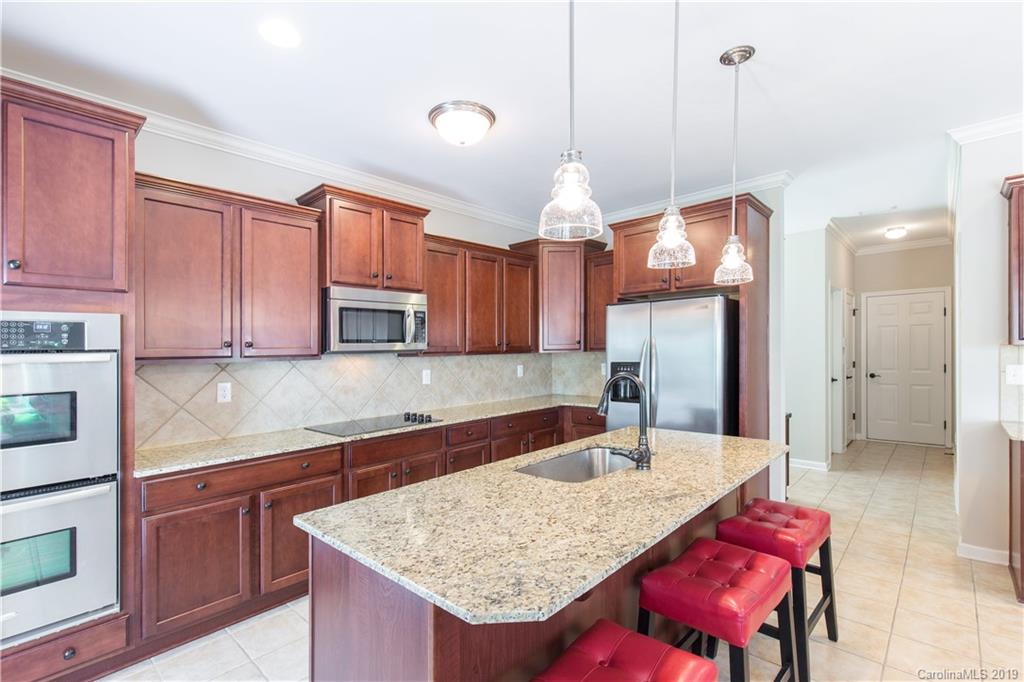 3347 Mandrake Court Tega Cay, SC 29708 - Photo 5 of 27 a kitchen with granite countertop a sink a stove and cabinets