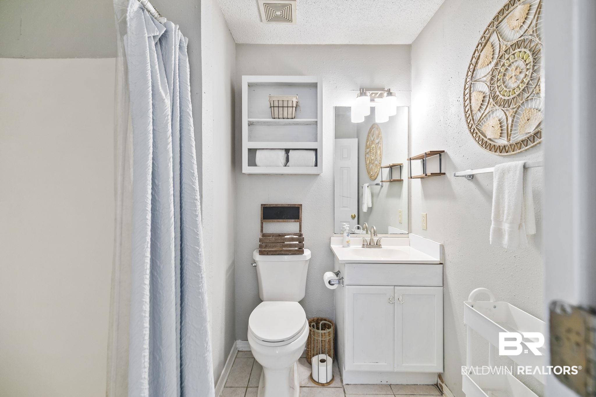 25957 Canal Road, Unit 302 Orange Beach, AL 36561 - Photo 12 of 26 Bathroom featuring tile patterned floors, toilet, a textured ceiling, and vanity