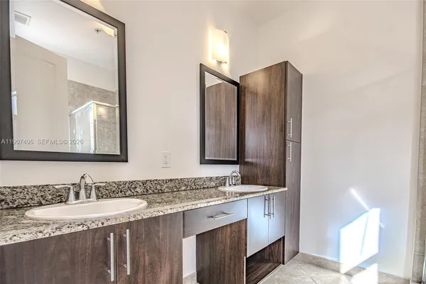 a bathroom with a granite countertop sink and a mirror