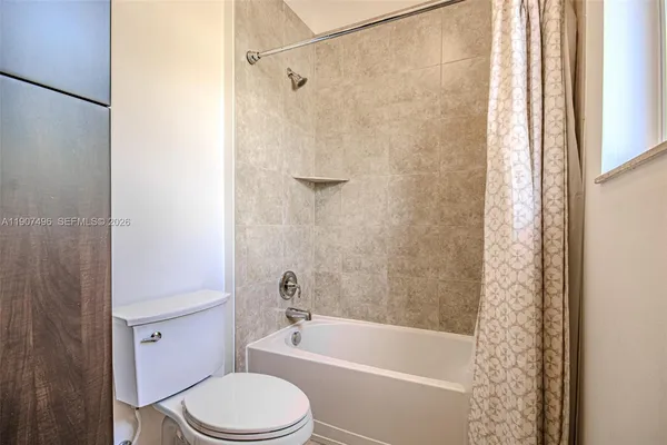 a bath room with a toilet and a bath tub