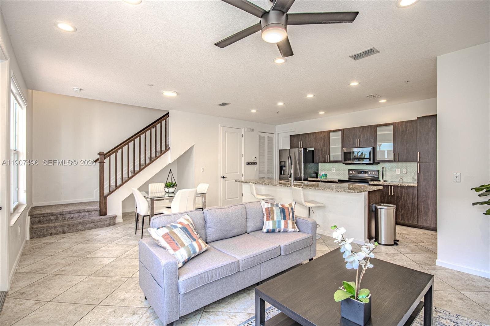 1430 Northwest 48th Drive Boca Raton, FL 33431 - Photo 4 of 33 a living room with furniture kitchen view and a wooden floor