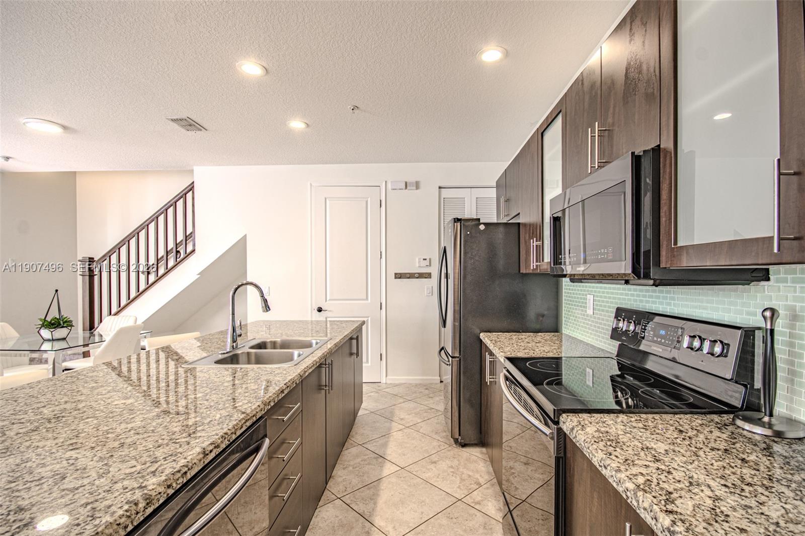 1430 Northwest 48th Drive Boca Raton, FL 33431 - Photo 8 of 33 a kitchen with stainless steel appliances granite countertop a sink a stove and a refrigerator