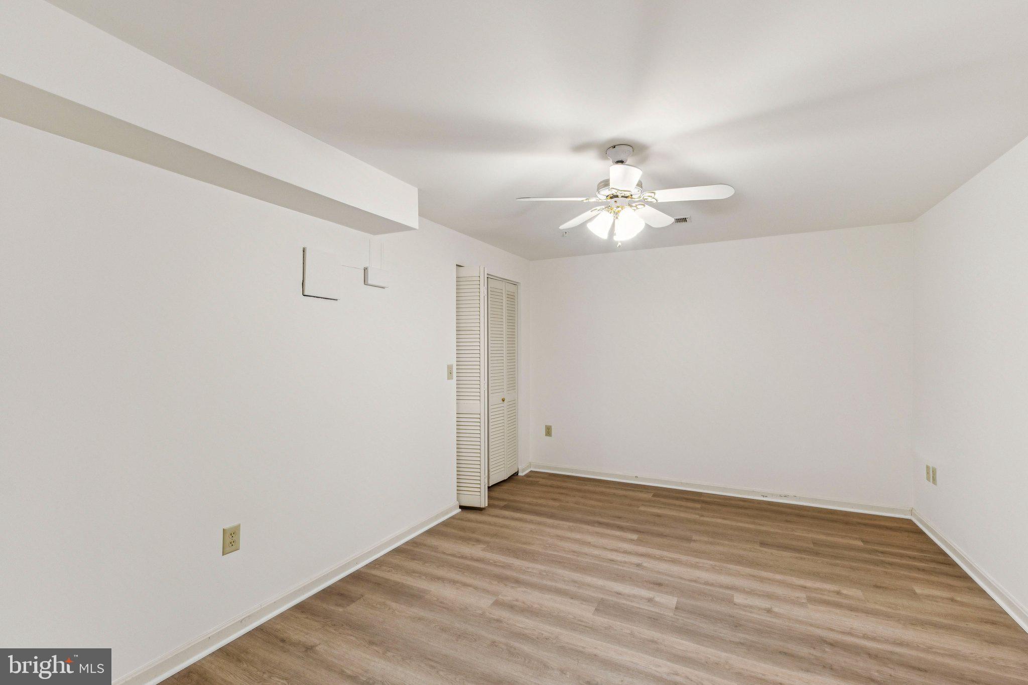 12205 Quick Fox Lane Bowie, MD 20720 - Photo 20 of 39 a view of a room with wooden floor and a ceiling fan