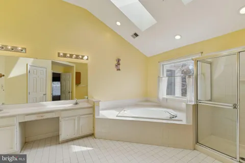 a bathroom with a bathtub shower sink and mirror