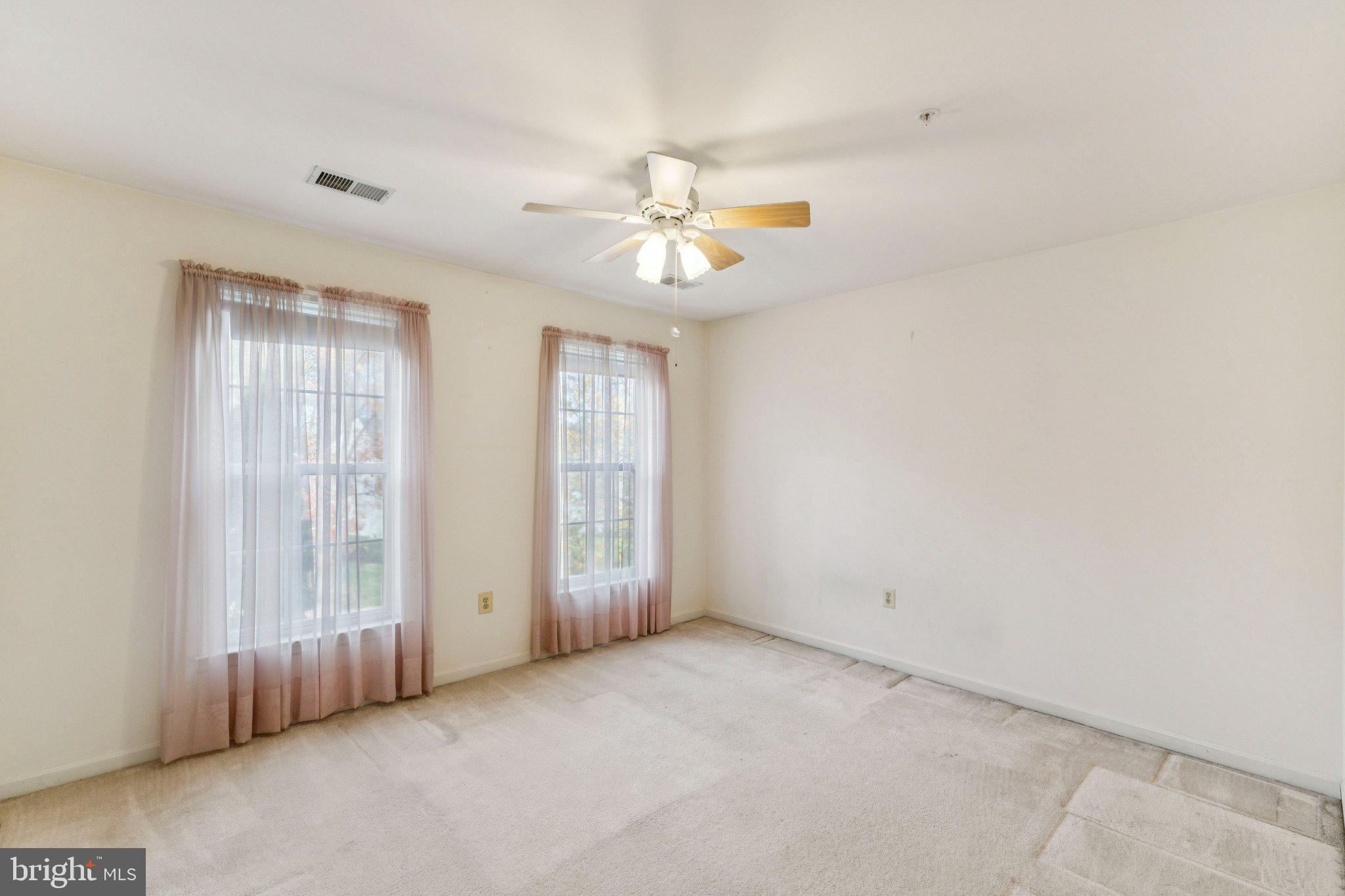 12205 Quick Fox Lane Bowie, MD 20720 - Photo 28 of 39 an empty room with chandelier fan and windows