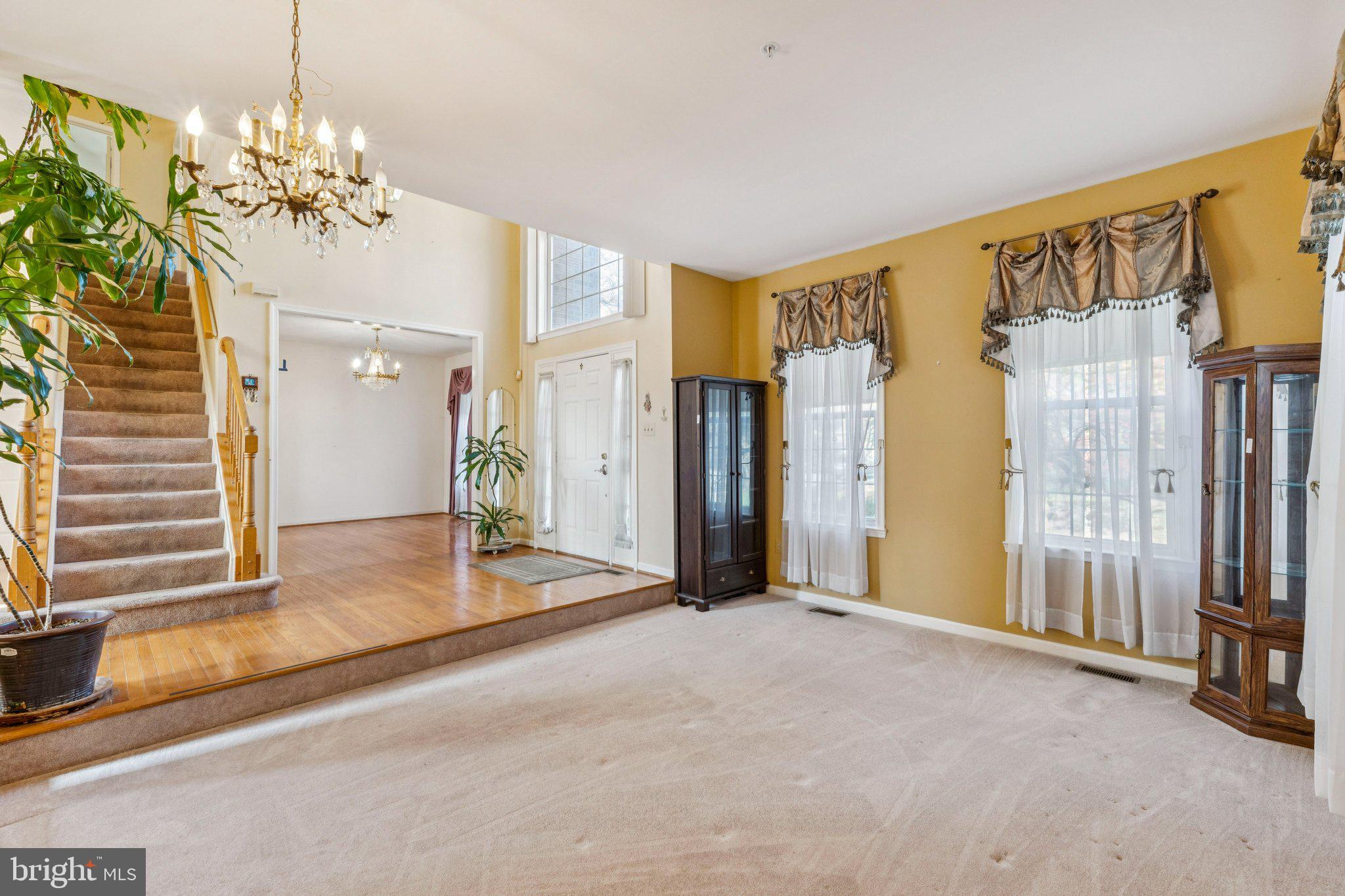 12205 Quick Fox Lane Bowie, MD 20720 - Photo 3 of 39 a view of a big room with chandelier front door and windows