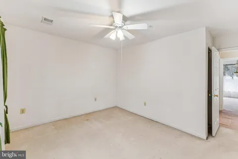 an empty room with a ceiling fan and a window